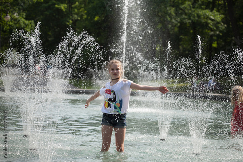 Enjoy fountain, young girl bathes in a city fountain 