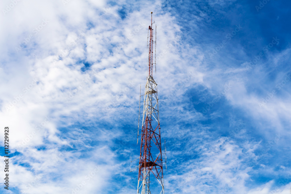 red and white telecommunication tower on blue sky background