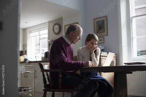 Granddaughter Helping Grandfather To Use Laptop Computer