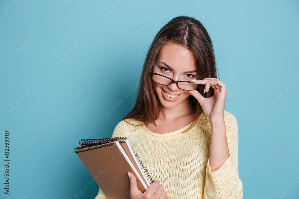 Close-up portrait of girl in glasses over blue background Close-up portrait of girl in glasses over blue background