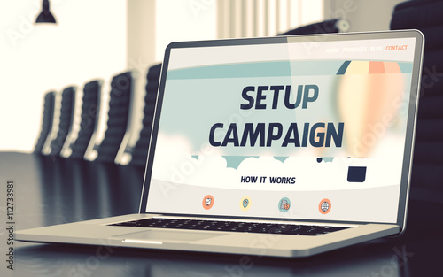 Mobile Computer Display with Setup Campaign Concept on Landing Page. Closeup View. Modern Meeting Hall Background. Blurred Image with Selective focus. 3D Render.