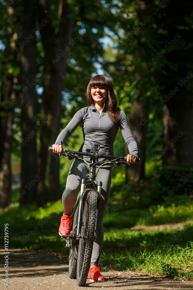 Naklejka premium cyclist woman riding a bicycle in park