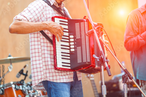 Close up musicians are playing accordion on stage photo