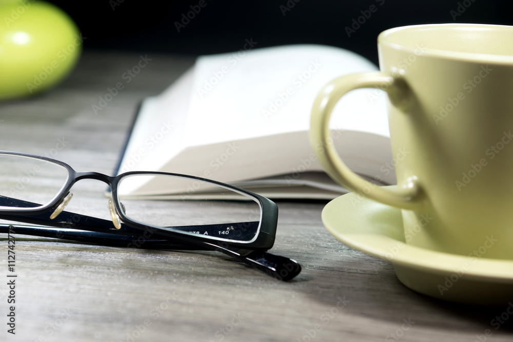 Kaffeetasse, Lesebrille und ein Buch Kaffeetasse, Lesebrille und ein Buch