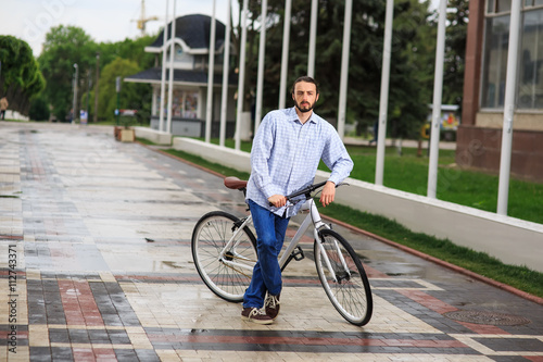 Fototapeta Naklejka Na Ścianę i Meble -  young hipster man with fixed gear bike on city street