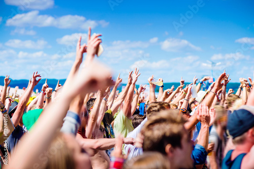 Teenagers at summer music festival clapping and singing