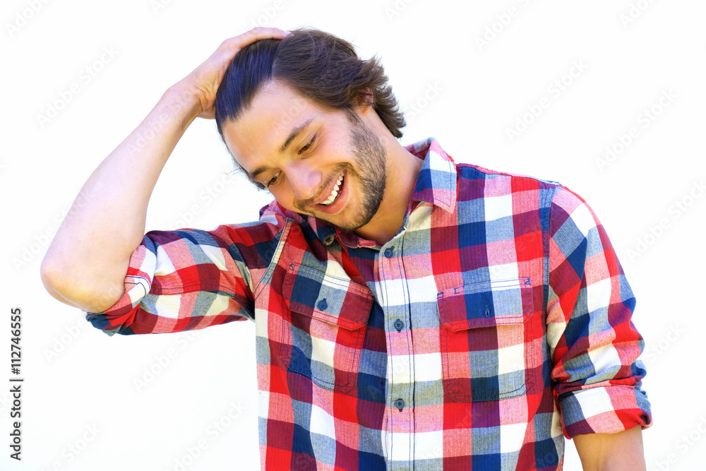 Handsome young man smiling with hand in hair Handsome young man smiling with hand in hair