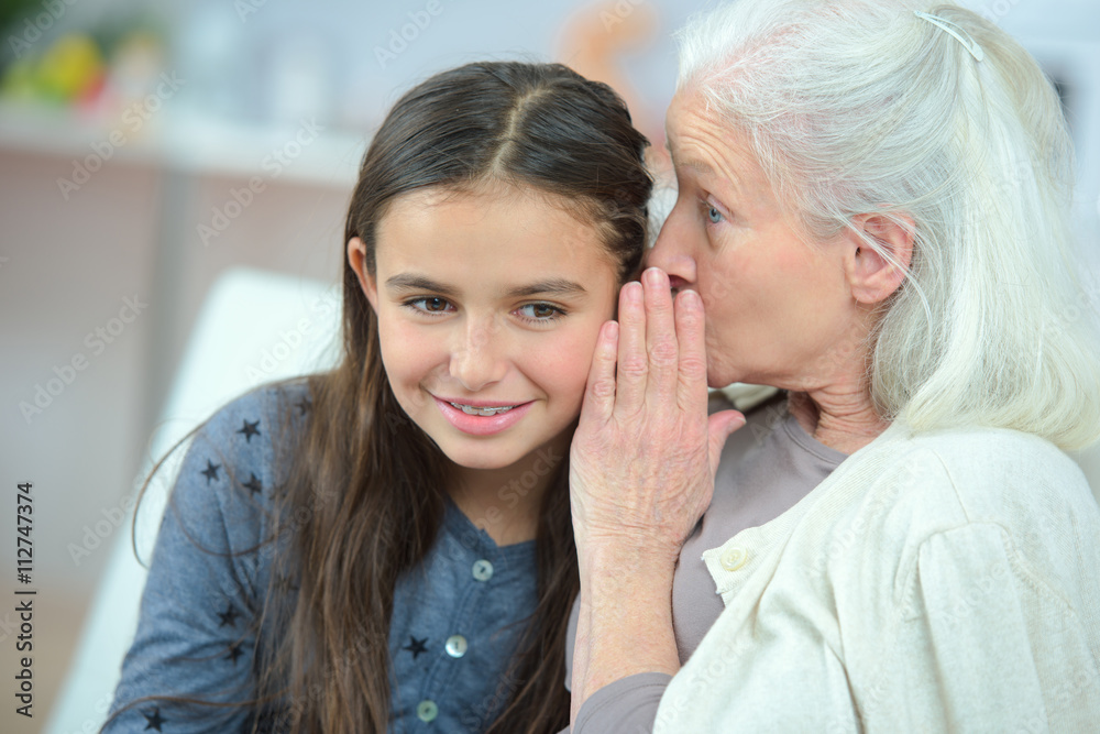 Little girl and grandma whispering secrets Little girl and grandma whispering secrets