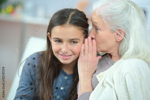 Little girl and grandma whispering secrets