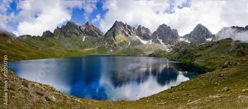 Panorama of lake in Georgia against the background of snowy mountain range photo