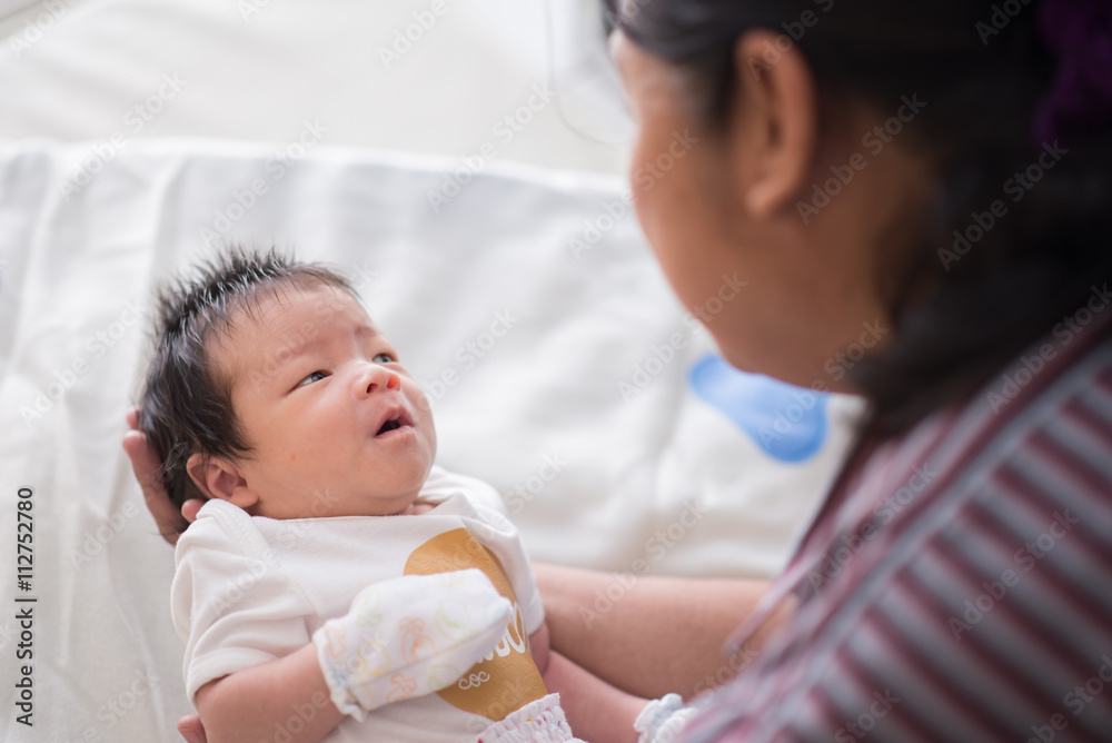 Cute asian baby newborn looking at grandmom Cute asian baby newborn looking at grandmom