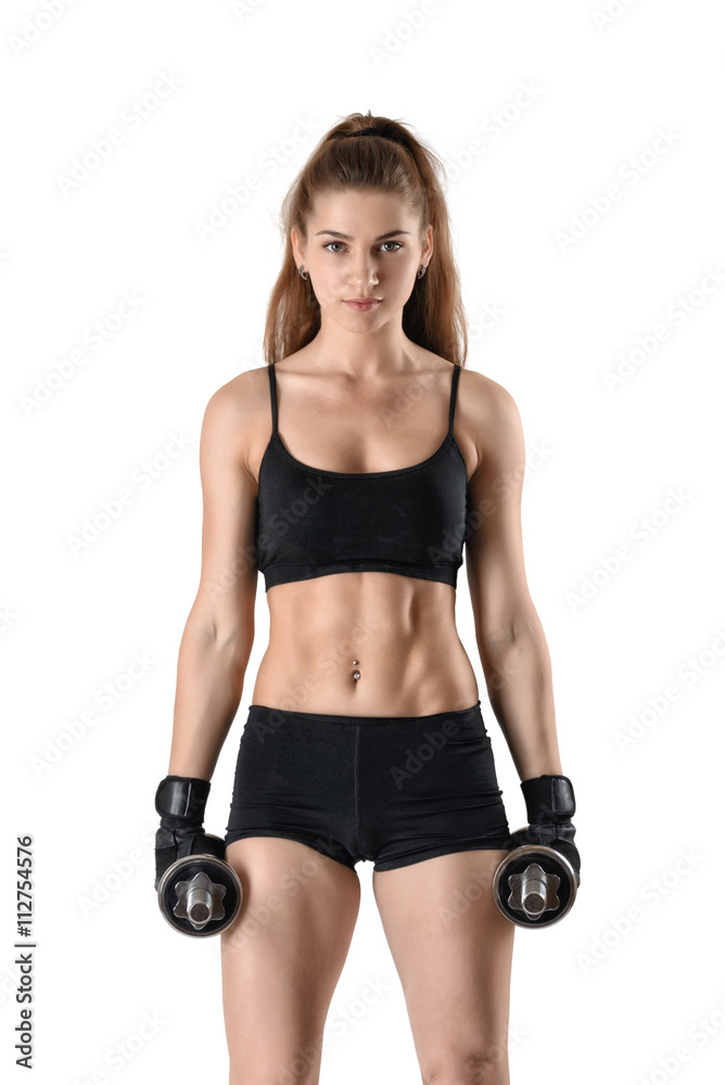 Cutout fitness model wearing sportswear stands looking directly at the camera, holding dumbells. Cutout fitness model wearing sportswear stands looking directly at the camera, holding dumbells.