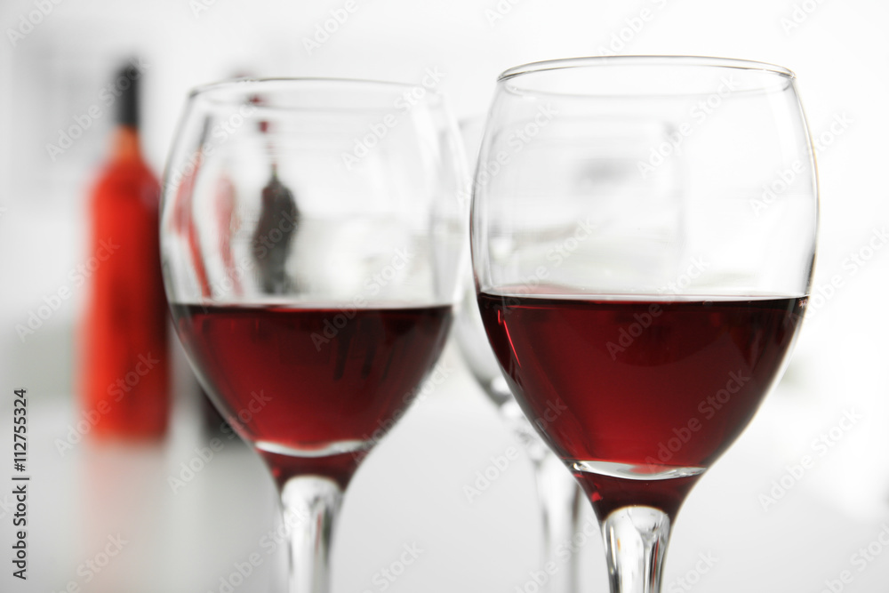 Glasses of red wine on white table closeup Glasses of red wine on white table closeup