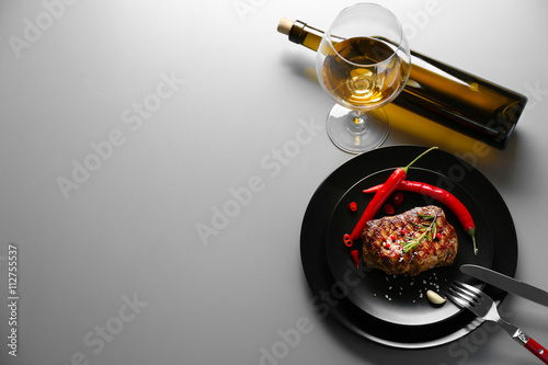 Delicious grilled steak on plate with white wine