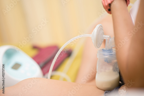 Mother doing breast feeding electronic for her baby milk stock