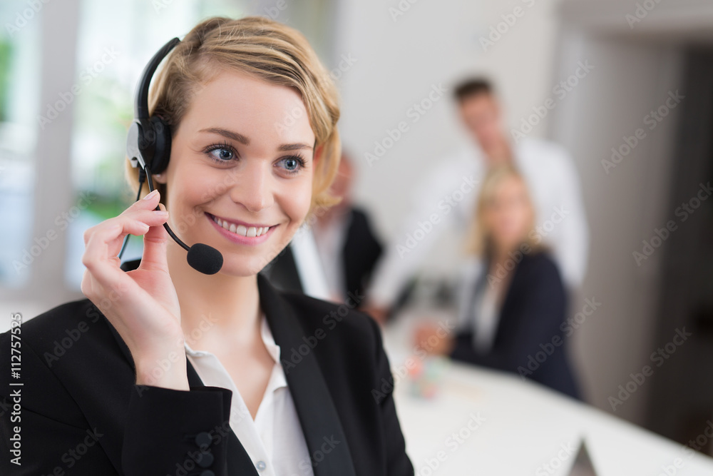 Portrait of a smiling creative businesswoman with earpiece in office.. Portrait of a smiling creative businesswoman with earpiece in office..