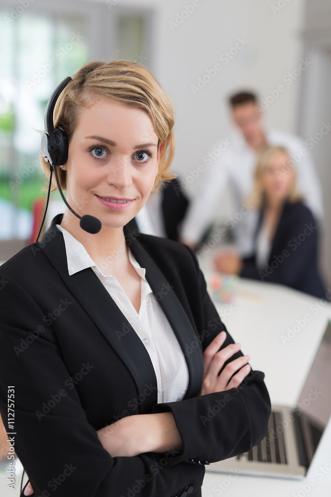 Portrait of a smiling creative businesswoman with earpiece in office.. Portrait of a smiling creative businesswoman with earpiece in office..