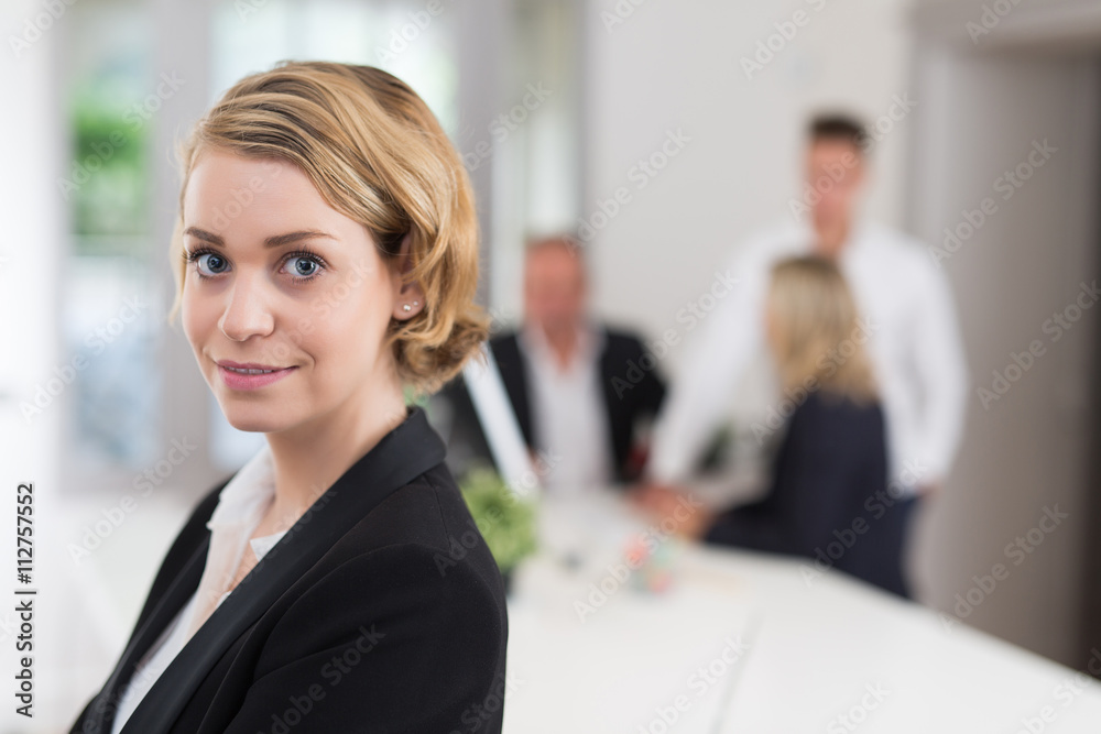Happy businesswoman with colleagues in the background Happy businesswoman with colleagues in the background