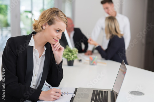 Happy businesswoman with colleagues in the background