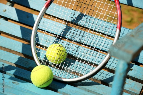 Tennis balls and racket on a blue background