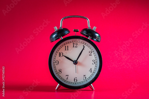 Retro alarm clock with Ten o'clock and five minute on white background .Retro Clock with red background. Black retro alarm.Clock concept. Retro Clock. Black clock. Clock alarm at ten o'clock.