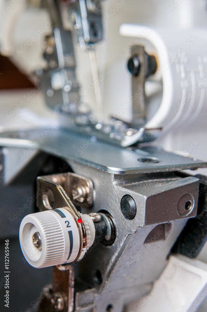 Fototapeta premium Sewing machine with fabric industrial overlock mechanism