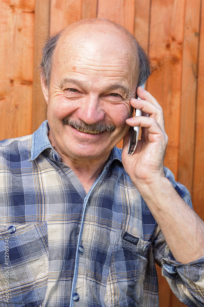 Elderly man talking on the phone. Maintaining family ties at a distance. Order by phone Elderly man talking on the phone. Maintaining family ties at a distance. Order by phone