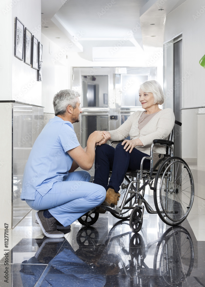 Physiotherapist Holding Senior Woman's Hand On Wheelchair Physiotherapist Holding Senior Woman's Hand On Wheelchair