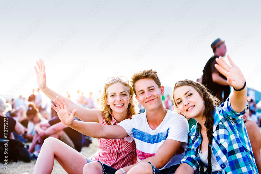Teenagers at summer music festival, sitting on the ground Teenagers at summer music festival, sitting on the ground