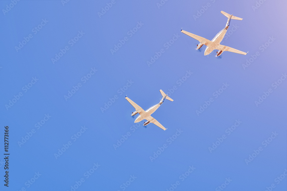 Two small aircrafts flying in a blue sky Two small aircrafts flying in a blue sky