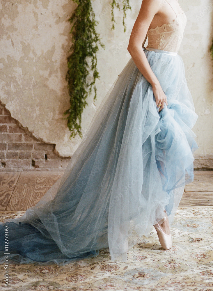 Cropped side view of ballet dancer wearing blue chiffon skirt Cropped side view of ballet dancer wearing blue chiffon skirt