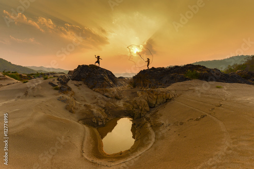 fisherman throwing nets during on sunset in Meakhong river Thai-Loas photo