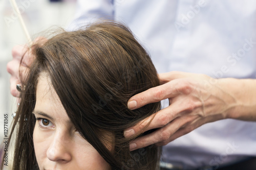 Beautiful female client coloring hair in hair studio