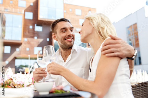 happy couple drinking wine at open-air restaurant