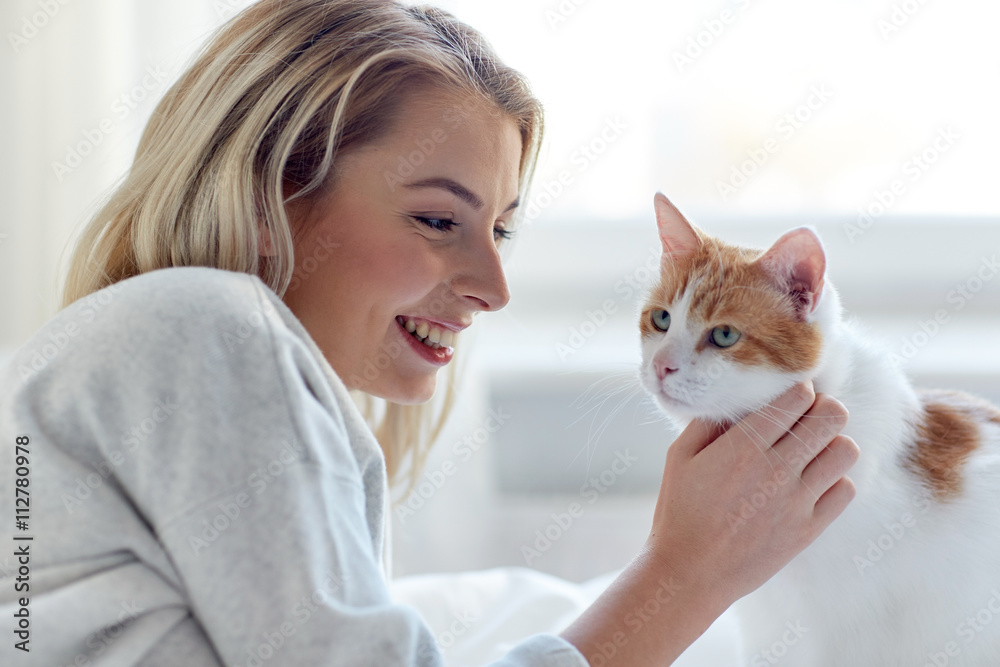 happy young woman with cat in bed at home happy young woman with cat in bed at home