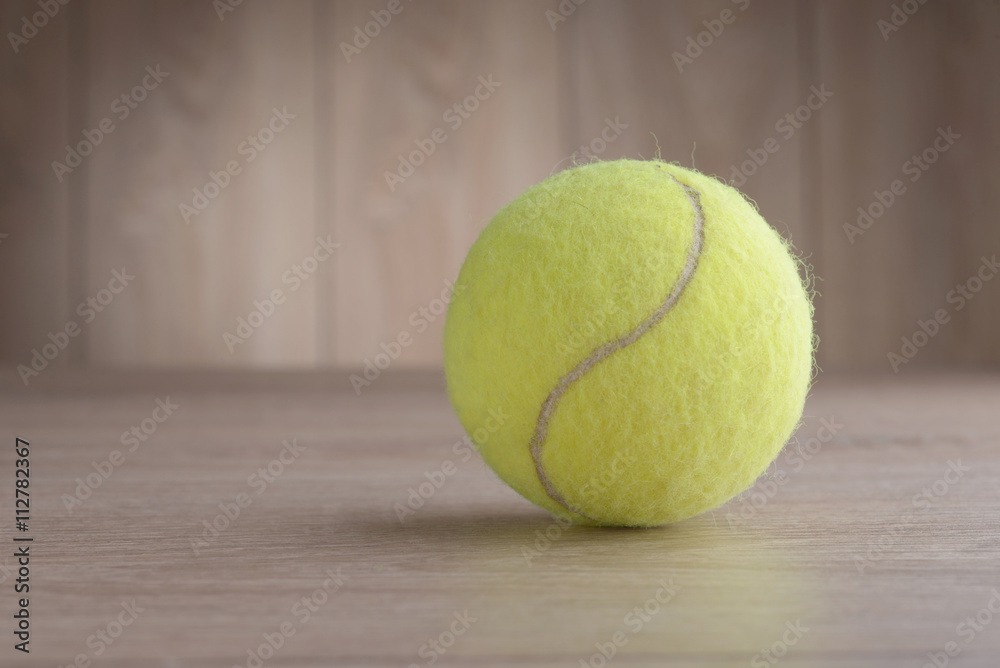 Tennis ball on a wooden floor.
