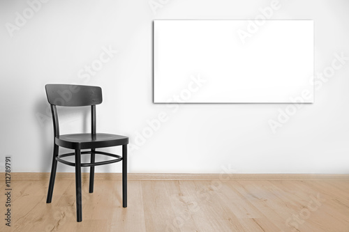 Fototapeta Naklejka Na Ścianę i Meble -  Black chair and picture frame on wall background