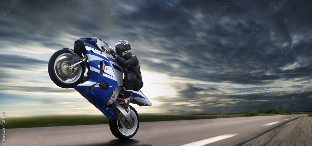 Obraz premium Szybki Wheelie na niebieskim motocyklu