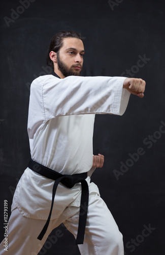 Karate Fighter in white Kimono Isolated on Black with Copy space