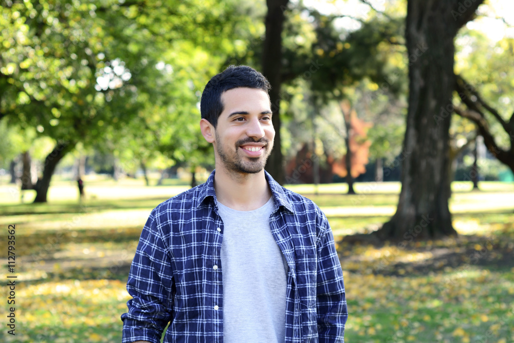 Close up of young man in a park. Close up of young man in a park.
