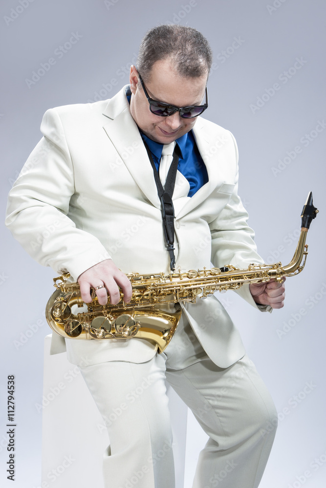 Fototapeta premium Music Concept and Ideas. Handsome Caucasian Musician with Saxophone Against White
