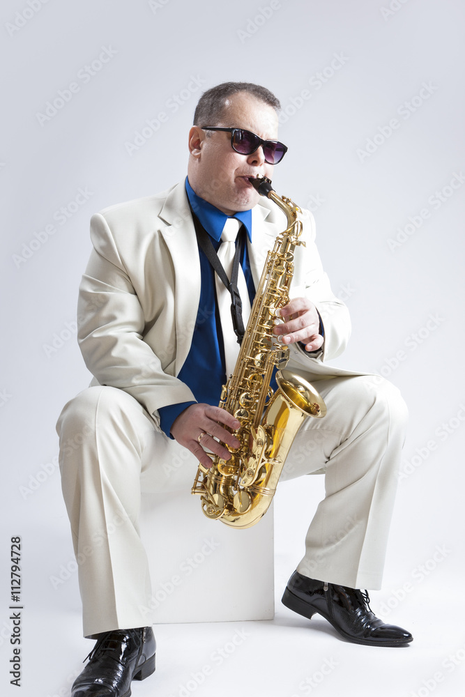 Fototapeta premium Music Ideas and Concepts. Handsome and Caucasian Music Player Posing with Alto Saxophone Against White