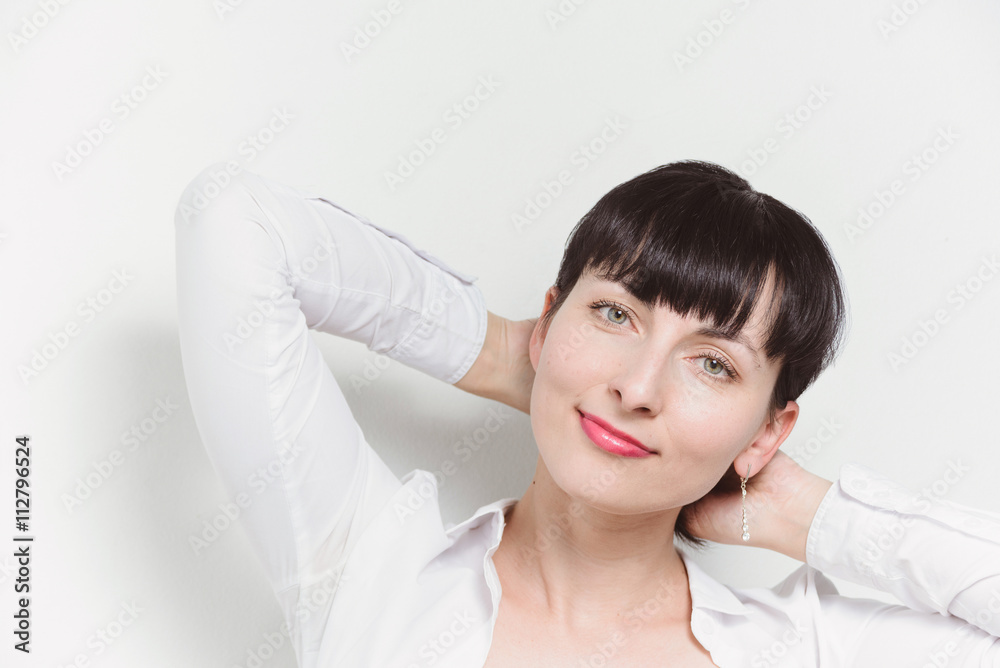 Beautiful young model woman in white shirt posing over white ba Beautiful young model woman in white shirt posing over white ba