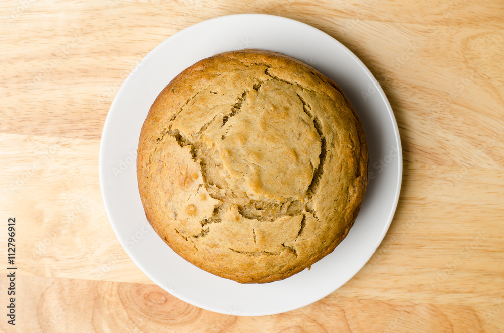 Homemade banana cake on white plate and wooden background