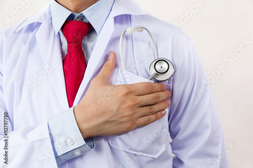 Medical doctor putting stethoscope in pocket, ready for hard work and having faith