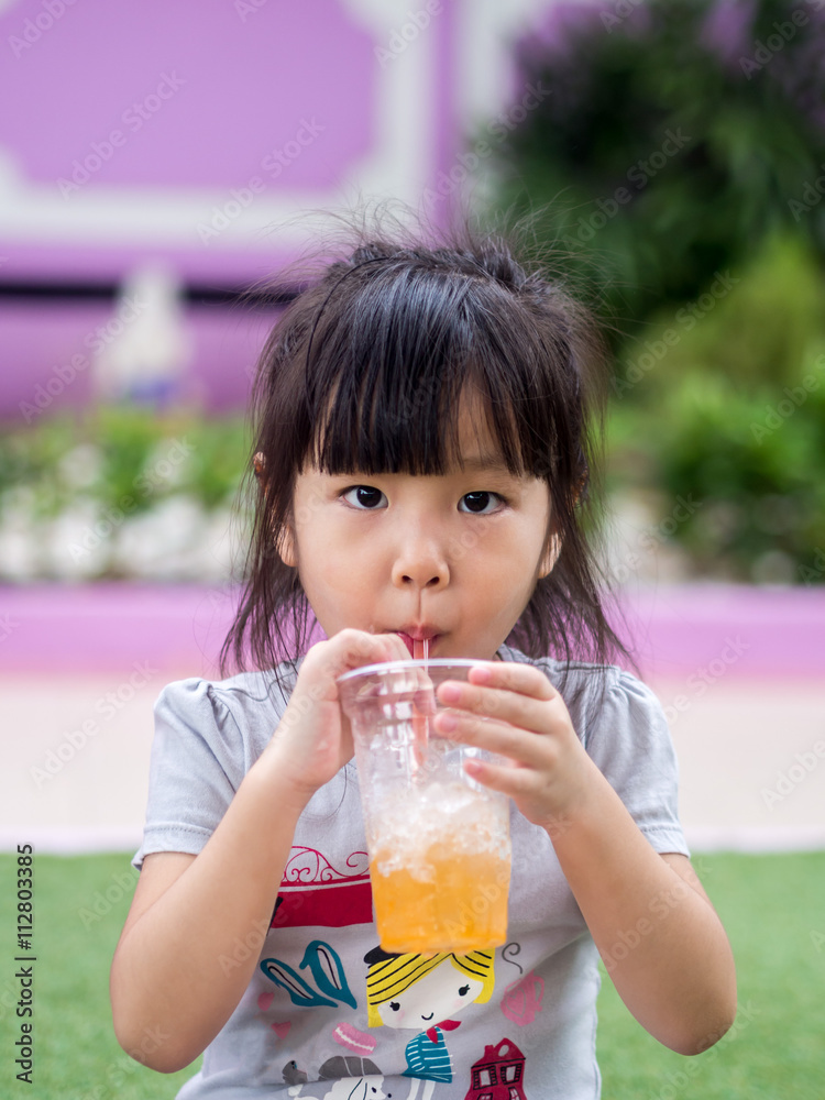 Beautiful asian girl drinking with a straw Beautiful asian girl drinking with a straw