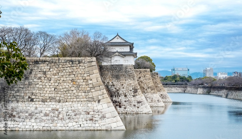 The famous heritage, Osaka castle under bright blue dramatic cloudy sky and sunshine in Japan photo