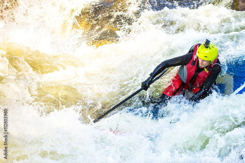 The man supsurfing on the rapids of the mountain river photo