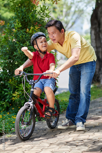 Father showing his child where he should cycling