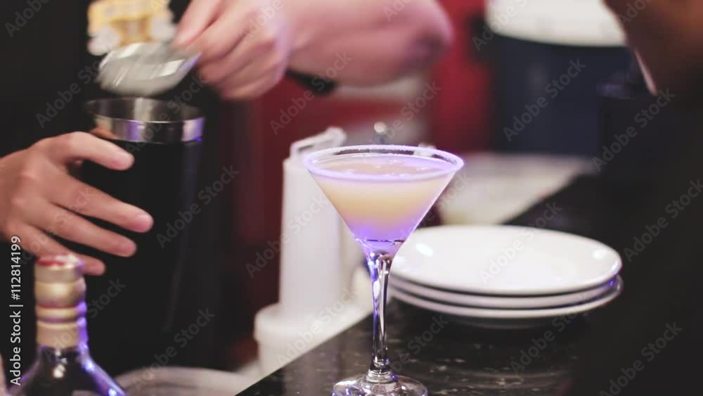 Barman at work, preparing cocktails. pouring to cocktail glass. concept about service and beverages Barman at work, preparing cocktails. pouring to cocktail glass. concept about service and beverages